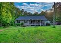 Charming single-story home with a covered porch, and lush landscaping at 160 Riverbrooke Trl, Covington, GA 30016