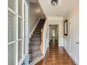 Inviting foyer with hardwood floors, staircase, and natural light filtering through the glass front door at 1928 Stancrest Nw Trce, Kennesaw, GA 30152