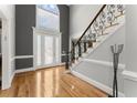 Elegant foyer featuring hardwood floors, decorative front door, and an ornate staircase at 300 Morganshire Pl, Atlanta, GA 30350
