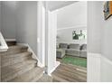 Inviting entryway with a carpeted staircase and view into the living room with a comfortable gray sofa at 4131 N Gloucester Pl, Atlanta, GA 30341