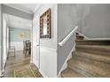 Bright entryway with carpeted stairs, a view to the dining room, and decorative wall accents at 4131 N Gloucester Pl, Atlanta, GA 30341