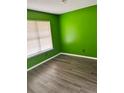 Cozy bedroom with light-filled window, sleek floors, and eye-catching green paint at 432 Manor Estates Dr, Stockbridge, GA 30281