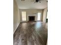 Spacious living room features a brick fireplace, modern ceiling fan, and beautiful wood floors at 432 Manor Estates Dr, Stockbridge, GA 30281