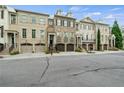 Charming townhome street view with brick exteriors, front garages, and manicured lawns at 9056 Riverbend Mnr, Alpharetta, GA 30022