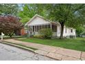 Quaint home with a screened-in porch surrounded by trees and a lush lawn at 1792 Center Ave, East Point, GA 30344