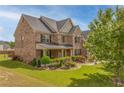 Beautiful two-story brick home with a well-manicured lawn, landscaping, and mature trees at 3039 Tuscan Ridge Dr, Snellville, GA 30039