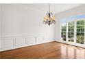 Bright dining room featuring hardwood floors, large window, and chandelier at 5725 Lake Oak Lndg, Cumming, GA 30040