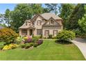 Charming home featuring a landscaped front yard and inviting curb appeal with a brick facade at 5725 Lake Oak Lndg, Cumming, GA 30040