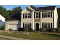 Charming two-story home with a two-car garage, manicured lawn and stone around the entryway at 1371 Blazing Star Rd, Lawrenceville, GA 30045
