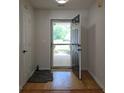 Inviting entryway with hardwood flooring and a view of the landscaped front yard through the storm door at 282 Ellesmere Court, Buford, GA 30518