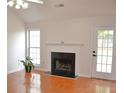 Bright living room features a fireplace, beautiful wood floors, vaulted ceilings and natural light at 282 Ellesmere Court, Buford, GA 30518