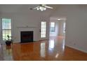 Bright and airy living room featuring a fireplace, hardwood floors and access to the backyard at 282 Ellesmere Court, Buford, GA 30518
