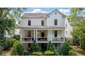 Charming white home featuring a covered front porch with columns and an American flag at 6715 Pond Rd, Cumming, GA 30040