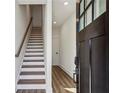 Bright entryway with wood floors, white walls, a staircase, and modern black hardware at 101 Mission Se Way # 101, Atlanta, GA 30315