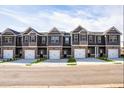 New construction townhomes featuring two-car garages, modern architecture, and professionally landscaped yards at 235 Ivey Ter, Temple, GA 30179