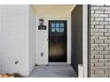 Close-up of the front door with painted brick, stylish sconce, and house number at 103 Mission Se Way # 103, Atlanta, GA 30315