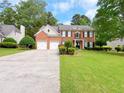 Classic brick home boasts a two-car garage, landscaped yard, and symmetrical design, creating a welcoming curb appeal at 2049 Mclain Nw Rd, Acworth, GA 30101