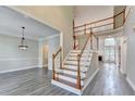 Spacious two-story foyer featuring hardwood floors, staircase with wooden banister and views into living spaces at 2049 Mclain Nw Rd, Acworth, GA 30101