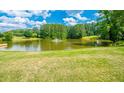 Picturesque pond with a fountain surrounded by lush green grass, providing a serene and scenic view at 2049 Mclain Nw Rd, Acworth, GA 30101