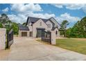 View of the home and gated driveway, showing its architectural details and landscaping at 3203 Bold Springs Rd, Dacula, GA 30011