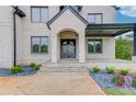 Close-up of the front entrance with stone steps, a modern door, and tasteful landscaping at 3203 Bold Springs Rd, Dacula, GA 30011
