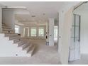 A bright, unfinished living room with stairs and large windows offering natural light at 3203 Bold Springs Rd, Dacula, GA 30011