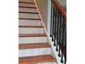 Wooden staircase with white risers and decorative iron railing adds charm to the home at 4075 Sw Fairburn Sw Ave, Atlanta, GA 30331
