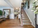 Inviting foyer with wood floors, staircase, and a large mirror, offering a glimpse into the living area at 6215 Barley Sq, Sugar Hill, GA 30518