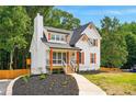 Beautiful home with a gray roof, white siding, and professionally landscaped front yard at 77 Township Drive, Hiram, GA 30141