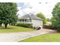 This home features a spacious lawn, a long driveway, and a three-car garage at 68 Paradise Pointe, Douglasville, GA 30134