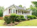Charming home featuring a welcoming front porch and beautifully landscaped front yard with lush greenery at 68 Paradise Pointe, Douglasville, GA 30134