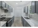 Updated kitchen with gray cabinets, light countertops, and new stainless steel oven at 9263 Club View Trce, Riverdale, GA 30274