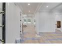 Bright hallway showcasing fresh paint, hardwood floors ready for finishing, and coffered ceiling architecture at 3205 Bold Springs Rd, Dacula, GA 30019