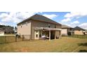 Spacious backyard featuring a covered patio, well-maintained lawn, and secure black metal fencing at 812 Graeme Dr, Mcdonough, GA 30252