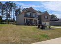 Spacious two-story home with a lush lawn and mature trees on a sunny day at 812 Graeme Dr, Mcdonough, GA 30252