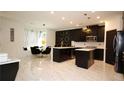 Modern kitchen with black cabinetry, marble floors, and an island for prepping at 812 Graeme Dr, Mcdonough, GA 30252