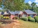 Charming single-story brick home featuring lush landscaping and an inviting front entrance at 925 Champions Way, Mcdonough, GA 30252