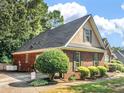 Charming single-story brick home with neat landscaping, a dark roof, and black shutters at 925 Champions Way, Mcdonough, GA 30252