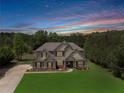 Beautiful home with mature trees and a lovely sunset sky at 127 Grayson Myers Dr, Villa Rica, GA 30180