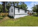 Well-maintained home featuring white siding, black trim, and lush green lawn at 4134 Burgess Dr, Decatur, GA 30035