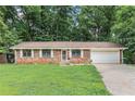 Well-kept single-story brick home with an attached garage and mature trees at 2954 Ann Marie Ln, Rex, GA 30273