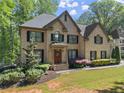 Beautiful two-story brick home features manicured landscaping, dark shutters, and an inviting front entrance at 4680 Brighton Lake Dr, Cumming, GA 30040