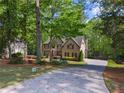 Elegant brick home with lush landscaping, a long driveway, and a serene, tree-lined setting at 4680 Brighton Lake Dr, Cumming, GA 30040