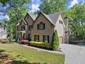 Attractive brick home with a side-entry garage, lush lawn, and mature trees providing ample shade at 4680 Brighton Lake Dr, Cumming, GA 30040