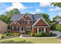 Beautiful two-story brick home with a well-maintained lawn, landscaping, and a welcoming facade at 5260 Harbury Ln, Suwanee, GA 30024