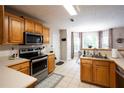 Bright kitchen featuring stainless steel appliances, wood cabinets, and tile flooring, with a view to the breakfast nook at 1020 Travitine Trl, Loganville, GA 30052
