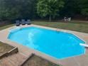 Aerial view of a large private inground swimming pool with an adjacent deck, diving board, and lounge chairs at 1020 Travitine Trl, Loganville, GA 30052