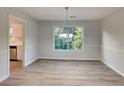 Dining room with wood-look floors, neutral paint, and natural light from a large window at 2352 Benson Rdg, Lithonia, GA 30058