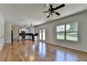 Open-concept kitchen and living room with hardwood floors, white cabinets, fireplace and backyard view at 3168 Sag Harbor Ct, Buford, GA 30519