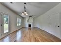 Spacious living room with hardwood floors, fireplace, ceiling fan, and doors leading to outdoor space at 3168 Sag Harbor Ct, Buford, GA 30519
